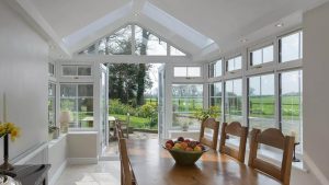 The inside of an extension with a dining table and opened French doors